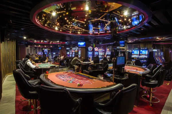 একজন নারী তার ল্যাপটপে অনলাইন গেম খেলছেন, চারপাশে নীলন আলোয় ক্যাসিনো উপাদান — যা KRIKYY–এর বৈচিত্র্যময় গেম সংগ্রহকে প্রদর্শন করে।