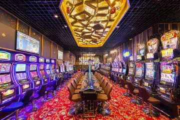 একজন পুরুষ তার ল্যাপটপে জয়ের মুহূর্ত উদযাপন করছেন, চারপাশে ভাসছে গেমিং আইকন—যা KRIKYY গেমসের উত্তেজনাকে প্রকাশ করে।